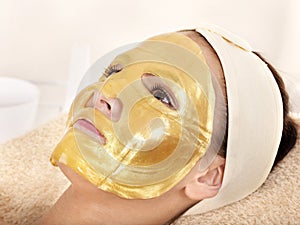 Girl with gold facial mask.