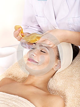 Girl with gold facial mask.