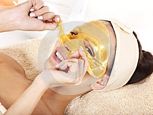 Girl with gold facial mask.