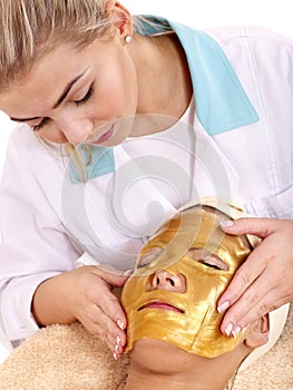 Girl with gold facial mask.