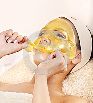 Girl with gold facial mask.