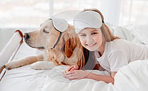 Girl with golden retriever dog in the bed