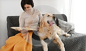 Girl with golden retriever dog reading book