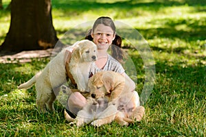 Girl and golden retriever pups