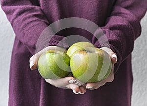 Girl golding three apples in her hands