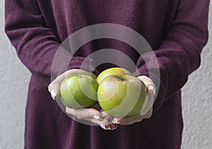 Girl golding three apples in her hands