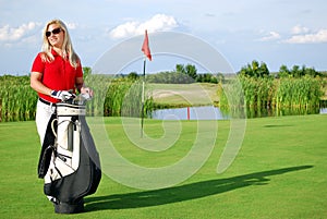 Girl with golf bag on golf course