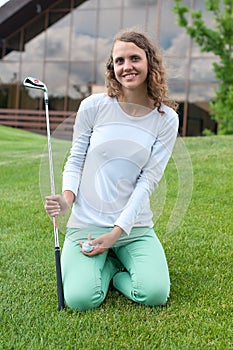 Girl golf player teeing off with driver