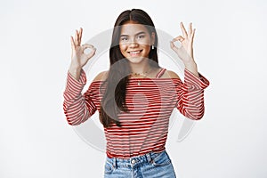 Girl got deal under control. Portrait of confident assuring and assertive charming young teenager in blouse showing okay