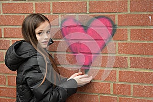 Girl and graffiti heart on a wall