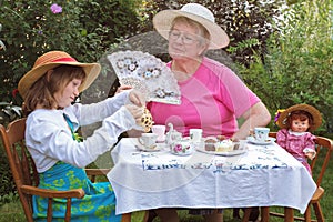 Girl and grandmother have a tea party