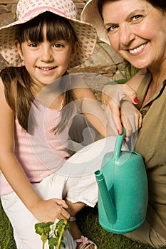 Girl and grandmother with watering can