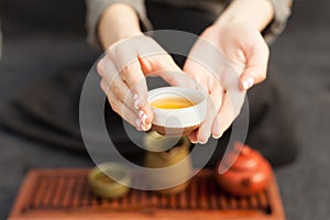 A girl in a gray linen shirt arranges a royal ceremony, classical accessories for a tea ceremony.