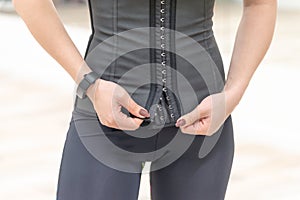 Girl in gray sports leggings unbutton corset photo