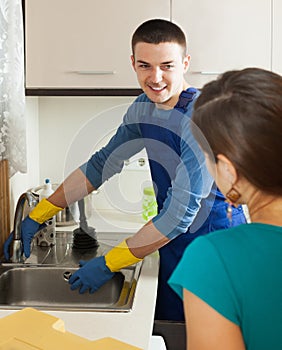 Girl in green watching plumbers work