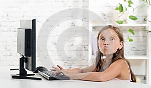 A girl grimaced front of a computer