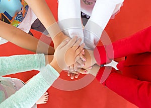 Girl group put their hands together in a circle. Sign of victory