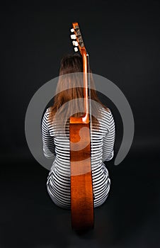 Girl with a guitar on a black background