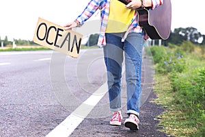 Girl with a guitar hitch-hiking