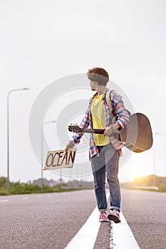 Girl with a guitar hitch-hiking