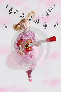 Girl with guitar on music notes background