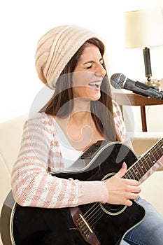 Girl with a guitar singing on microphone