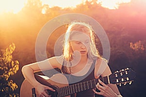 Girl guitarist playing guitar outdoor summer concept