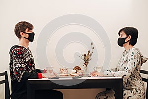 Girl and Guy Have Breakfast at Home in Masks