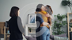 Girl and guy taking keys from housing agent shaking hands kissing and hugging