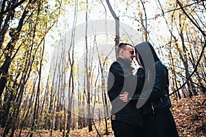 The girl and the guy are walking in the autumn forest