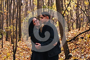 The girl and the guy are walking in the autumn forest