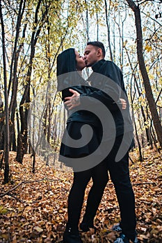 The girl and the guy are walking in the autumn forest