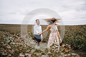 A girl and a guy are walking in the nature. Portrait of a couple, a love story.Happy smiling, loveing couple together outstretched