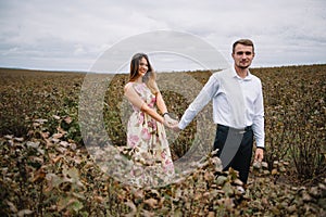 A girl and a guy are walking in the nature. Portrait of a couple, a love story.Happy smiling, loveing couple together outstretched