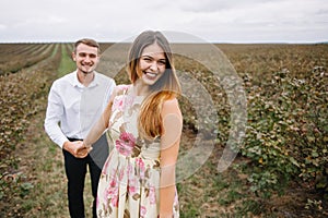 A girl and a guy are walking in the nature. Portrait of a couple, a love story.Happy smiling, loveing couple together outstretched