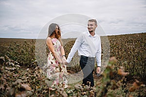 A girl and a guy are walking in the nature. Portrait of a couple, a love story.Happy smiling, loveing couple together outstretched