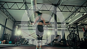 A girl in the gym trains. Sexy young woman is engaged in simulators in the gym. Beautiful sport figure.