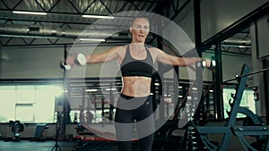 A girl in the gym trains. Sexy young woman is engaged in simulators in the gym. Beautiful sport figure.