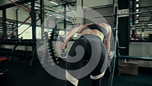 A girl in the gym trains. Sexy young woman is engaged in simulators in the gym. Beautiful sport figure.