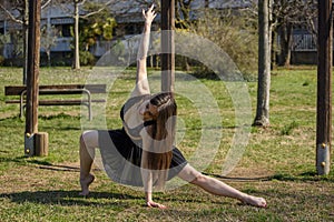 Girl gymnastic exercises in a public park