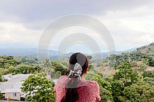 Girl with a hair bow watching the horizon in Cojutepeque, El Salvador
