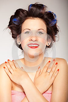Girl in hair curlers on gray