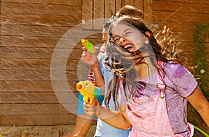 Girl with hair on face play water gun fight game