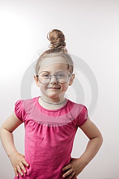Girl with hairbun wearing stylish trendy dress, round glasses and chain