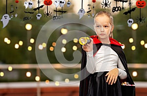 girl in halloween costume of dracula with candies