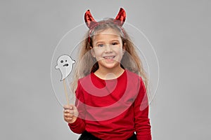 Girl in halloween costume with ghost party prop
