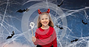 Girl in halloween costume with ghost party prop