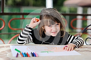 Girl in Halloween outfit draws pumkin