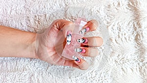 Halloween-themed pink and white ghost nail art photo