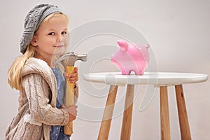 Girl, hammer and piggy bank in portrait for money, finance and investment for future in home. Female person, child and